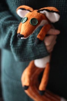 a person holding a stuffed animal in their hands