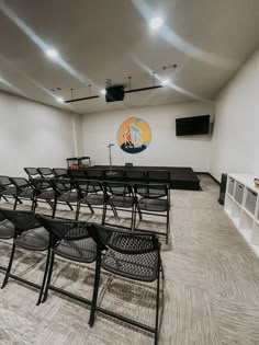 an empty room with black chairs and white walls