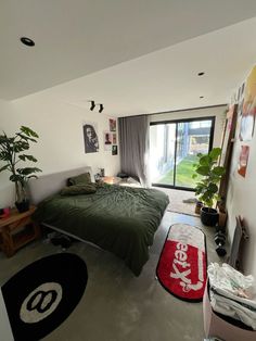 a bed room with a neatly made bed next to a window and a rug on the floor