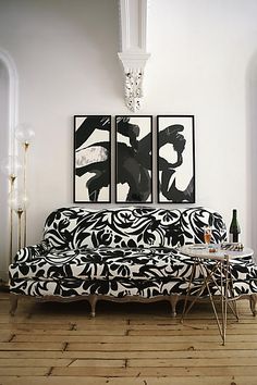 a living room with two paintings on the wall and a couch in front of it