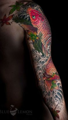 a man's arm with tattoos on it and a fish in the water behind him