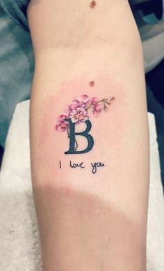 a woman's arm with a tattoo that says i love you and flowers on it