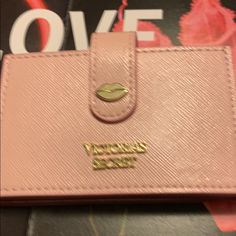 a pink purse sitting on top of a table next to a magazine with the word love written