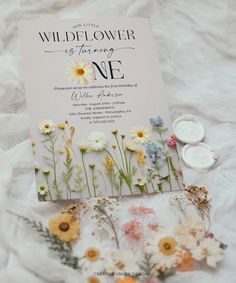 the wildflower is forging one wedding card and flowers are on top of it