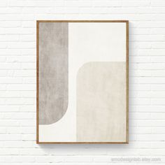 a white brick wall with an abstract painting hanging on it's side next to a wooden frame