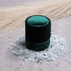 a green velvet ring sitting on top of some crushed up pieces of silver flakes