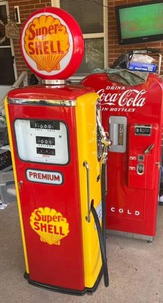 a red and yellow gas pump sitting next to a tv