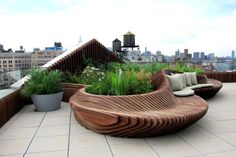 a wooden bench sitting on top of a roof next to plants and potted plants