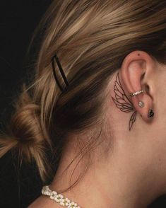 a woman with her hair in a bunt and some piercings on her ear