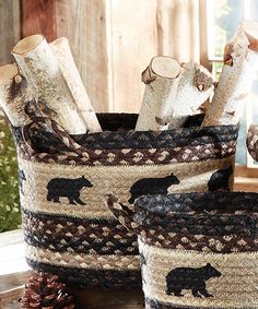 two woven baskets with bears on them and pine cones in the background, sitting on a table