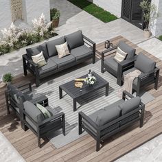 an outdoor living room with grey couches and coffee table on wooden flooring area