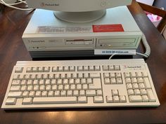 a computer keyboard sitting on top of a wooden desk next to a mouse and monitor