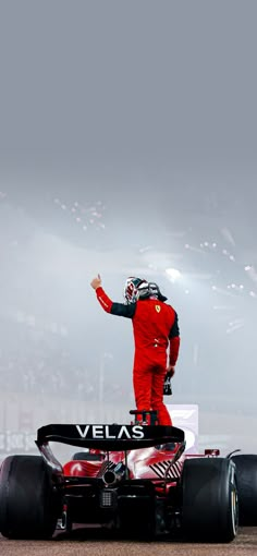 a man standing on top of a racing car