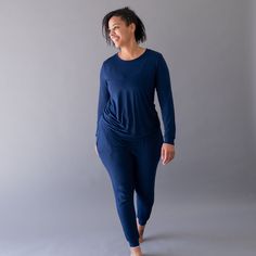 Woman wearing Kyte Baby women's jogger pajama set in Navy Stretch Tops With Elastic Waistband For Loungewear, Comfortable Fitted Joggers For Loungewear, Sporty Sleepwear With Elastic Waistband For Relaxation, Sporty Sleepwear With Elastic Waistband And Relaxed Fit, Blue Activewear With Ribbed Cuffs For Loungewear, Fitted Tops With Elastic Waistband For Loungewear, Stretch Athleisure Sleepwear For Loungewear, Athleisure Stretch Sleepwear For Loungewear, Athleisure Crew Neck Sleepwear For Lounging