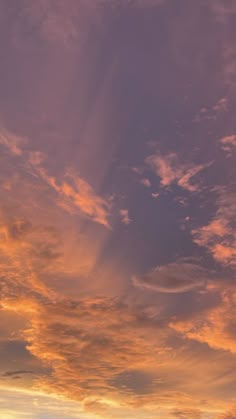 an airplane flying in the sky at sunset