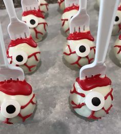 several toothbrushes with googly eyes are lined up on a counter top next to plastic spoons