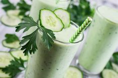 cucumber smoothie with green garnish in two glasses on a table