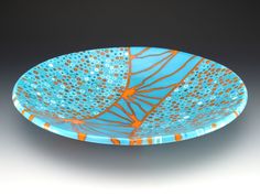 a blue plate with orange and white designs on it