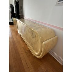 a marble bench sitting on top of a hard wood floor next to a white wall