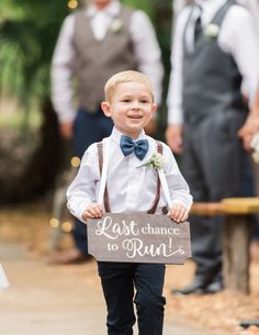 a young boy is holding a sign that says last chance to run down the aisle