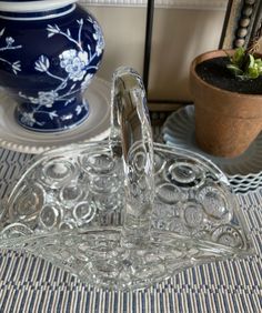 a glass water fountain sitting on top of a table next to a potted plant