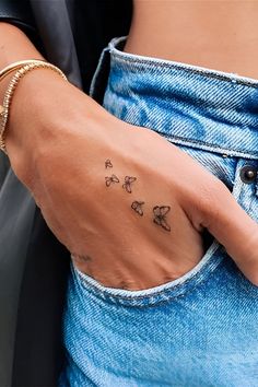 a woman's hand with a butterfly tattoo on her left wrist and the word love written in small butterflies