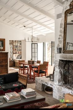 a living room filled with furniture and a fire place in front of a large mirror