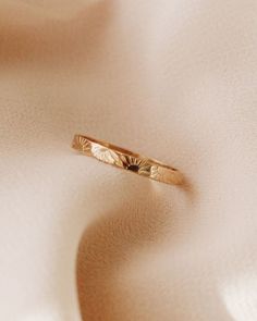 a gold ring sitting on top of a white cloth