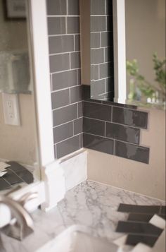 a white sink sitting under a bathroom mirror next to a tiled wall and counter top