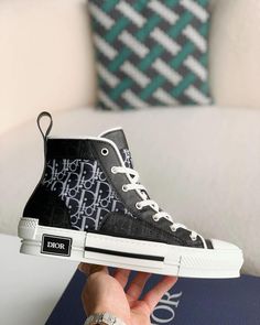 Embrace a blend of classic and contemporary style with these high-top sneakers inspired by the iconic Dior B23. Featuring a sleek black upper adorned with the signature Dior Oblique pattern, these shoes exude understated luxury. The contrasting white sole with a black stripe adds a sporty touch, while the high-top silhouette provides ankle support and a fashion-forward edge. Modern Medium Fit High-top Sneakers For Streetwear, Luxury High-top Sneakers With Contrast Sole, Designer High-top Sneakers With Contrast Sole, Luxury High-top Sneakers With Contrast Sole For Streetwear, Luxury High-top Sneakers With Branded Insole, Luxury High-top Lace-up Sneakers With Boost Midsole, Luxury High-top Sneakers With Boost Midsole For Streetwear, Luxury Lace-up High-top Sneakers With Boost Midsole, Luxury Lace-up High-top Sneakers With Contrast Sole