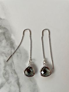 "Fine and delicate, these earrings flow from the earlobe in a beautiful silver line. Length can be adjusted depending how far the chain is pulled through the ear. These threader earrings measure 55mm in length. Hanging from one end of the chain is a beautiful faceted glass charm. Threader earrings come with wire ends to make it easy to thread the chain through any pierced hole of your ear, making these earrings fun to wear and play around with (from one pierced hole to another). Their versatilit Black Oak Tree, Gray Earrings, Suntan Lotion, Mary Oliver, Silver Line, Creating Jewelry, Threader Earrings, Faceted Glass, Jewelry Cleaner