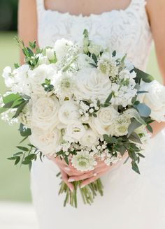 a bridal holding a bouquet of white flowers