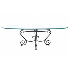 a glass table with wrought iron legs and a round glass top on an isolated white background