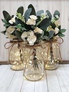 a vase filled with flowers and lights on top of a table