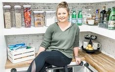 a woman sitting on top of a kitchen counter