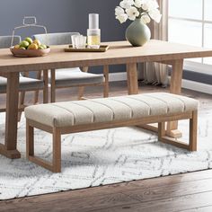 a wooden table with two benches in front of it and a vase on the side