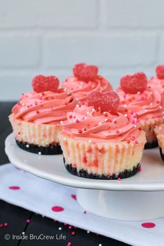 cupcakes with pink frosting and sprinkles on a white plate