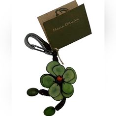 a keychain with a green flower attached to it's side and a tag hanging from the end