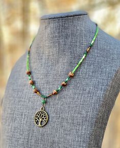 "Authentic Native American, handmade, Cedar Juniper Berry seed and Tree of Life pendant necklace. Cedar beads, colorful glass seed beads (size 11/0), round silver beads (6 mm) and a charm are strung with jewelry wire and closed with lobster claw clasp. Charm design is the same on both sides. Navajo legend says Cedar beads, also known as \"Ghost Beads,\" will keep evil spirits and bad dreams away. For example, it is customary for Navajo mothers to place strung cedar beads on/near their traditiona Bohemian Czech Glass Tiny Beads, Hippie Style Beaded Necklaces With Gemstone Beads, Bohemian Round Beaded Necklaces For Crafting, Green Beaded Hippie Necklace, Hippie Green Beaded Necklace, Adjustable Green Beaded Necklace With Nature-inspired Style, Adjustable Green Beaded Necklace In Nature-inspired Style, Holistic Beaded Festival Necklaces, Handmade Hippie Green Beaded Necklaces