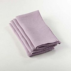 four folded napkins sitting on top of each other in front of a white background