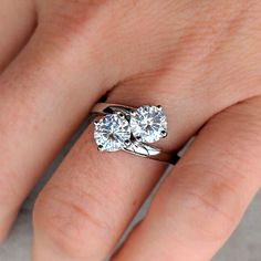 a woman's hand with two engagement rings on it