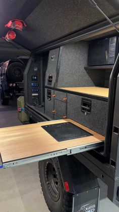 the interior of an rv with wood flooring and black appliances on it's side