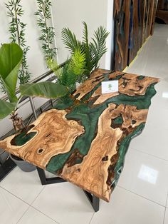 a table made out of wood with a plant in the middle and a sign on it