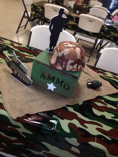 a camouflage table cloth with an army hat and cell phone on it