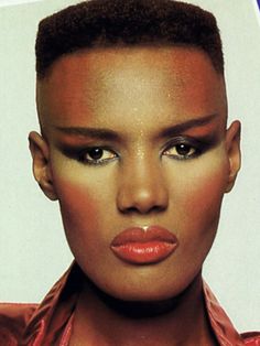 a close up of a person with makeup on their face and an afro hairstyle