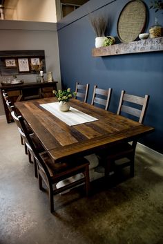 a dining room table with chairs and a potted plant