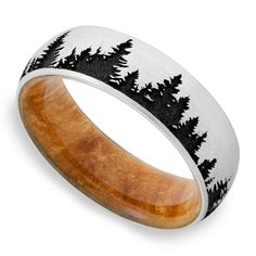 a wooden ring with black and white trees inlayed on the inside of it