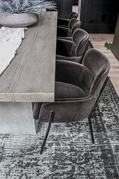 a dining room table with chairs and a rug on the floor in front of it