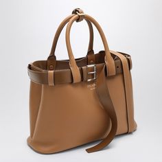 Caramel-coloured leather Prada medium bag featuring a decorative buckle belt, two top handles with strap detail, adjustable and removable shoulder strap, two internal compartments and contrasting front lettering logo. Width 33 cm x Height 22 cm x Depth 12 cm Adjustable shoulder strap length min 90 cm - max 100 cm Handle drop: 13 cm Size Type: INTMaterial: LeatherSKU: 1BA434OBO2CY9/O_PRADA-F03BH_100 Our Products Are 100% Genuine. In All Cases We Stand By The Authenticity Of Every Product Sold On Balenciaga Backpack, Buckle Bag, Buckle Bags, Belt Women, Medium Bag, Lettering Logo, Bottega Veneta Shoulder Bag, Louis Vuitton Shoulder Bag, Travel Collection