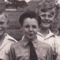 black and white photograph of four boys in uniform posing for the camera with one boy wearing a tie